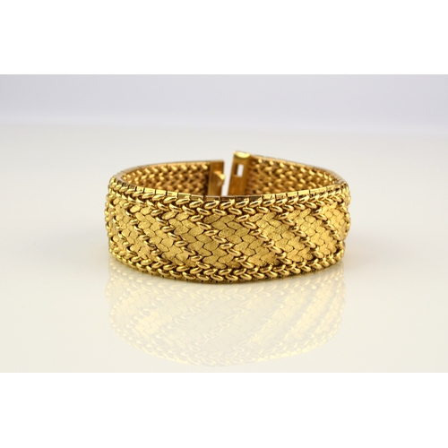 42 - A French yellow metal bracelet, the polished and textured integral links of stylised leaf design, wi... 