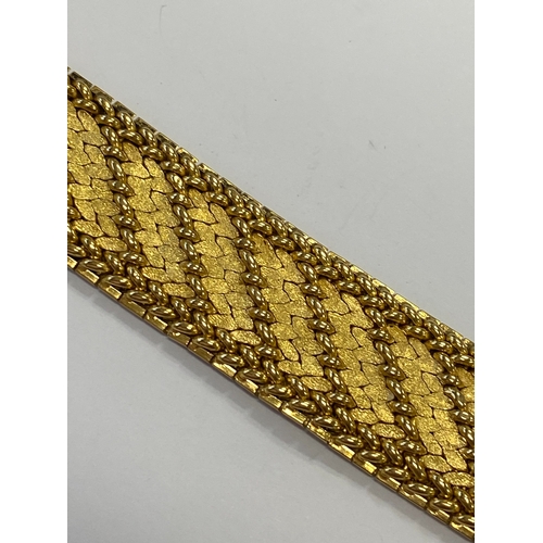 42 - A French yellow metal bracelet, the polished and textured integral links of stylised leaf design, wi... 
