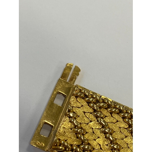 42 - A French yellow metal bracelet, the polished and textured integral links of stylised leaf design, wi... 