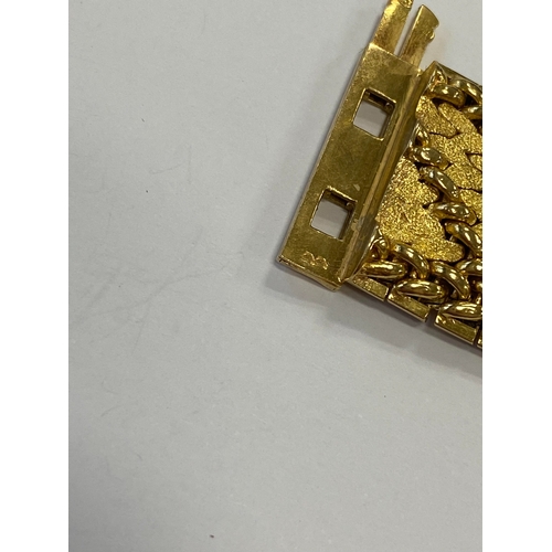 42 - A French yellow metal bracelet, the polished and textured integral links of stylised leaf design, wi... 