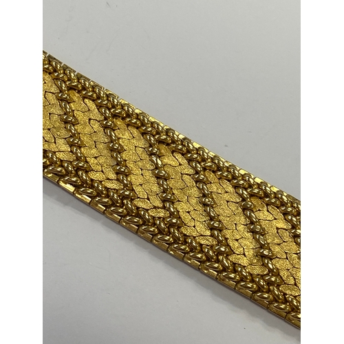 42 - A French yellow metal bracelet, the polished and textured integral links of stylised leaf design, wi... 