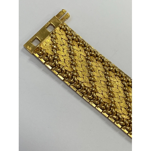 42 - A French yellow metal bracelet, the polished and textured integral links of stylised leaf design, wi... 