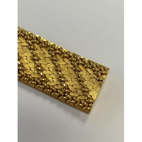 42 - A French yellow metal bracelet, the polished and textured integral links of stylised leaf design, wi... 
