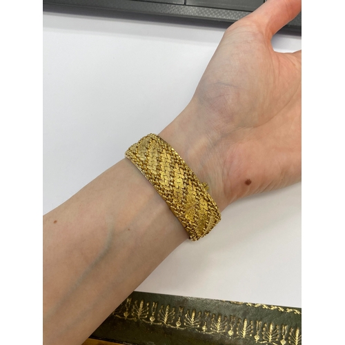42 - A French yellow metal bracelet, the polished and textured integral links of stylised leaf design, wi... 