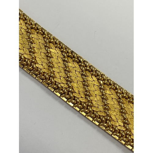 42 - A French yellow metal bracelet, the polished and textured integral links of stylised leaf design, wi... 