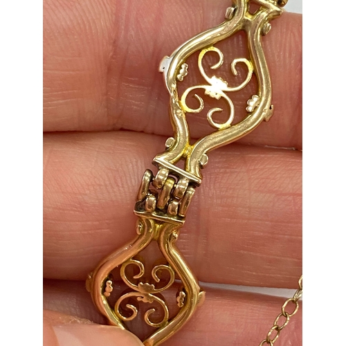 45 - A yellow metal decorative link bracelet, designed as seven openwork scroll links each interspersed w... 