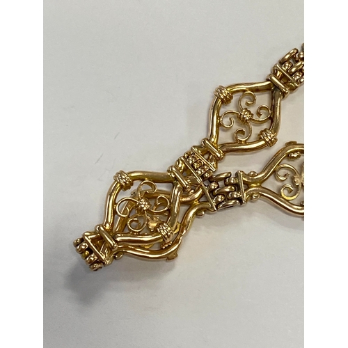 45 - A yellow metal decorative link bracelet, designed as seven openwork scroll links each interspersed w... 