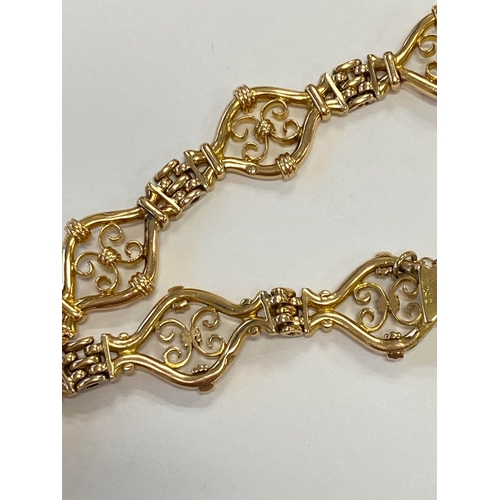 45 - A yellow metal decorative link bracelet, designed as seven openwork scroll links each interspersed w... 