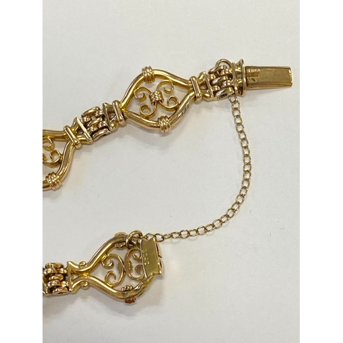 45 - A yellow metal decorative link bracelet, designed as seven openwork scroll links each interspersed w... 