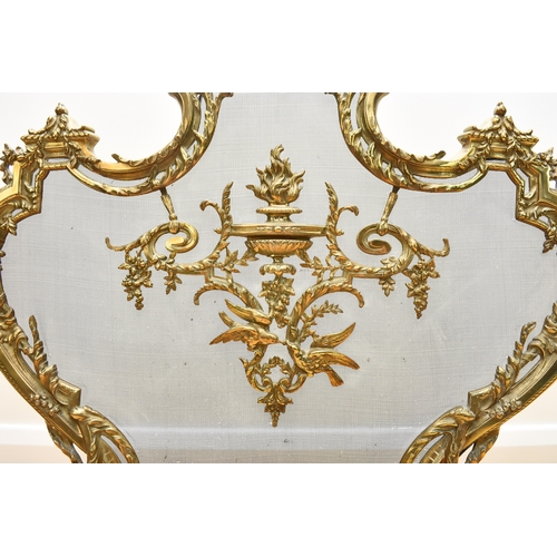 159 - A rococo revival cast brass fire screen Of shield form and cast in relief with scrolling foliage and... 