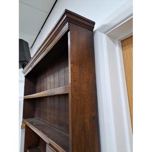170 - A George III oak cross-banded dresser and rack The ogee cornice above four shelves, the lower flanke... 