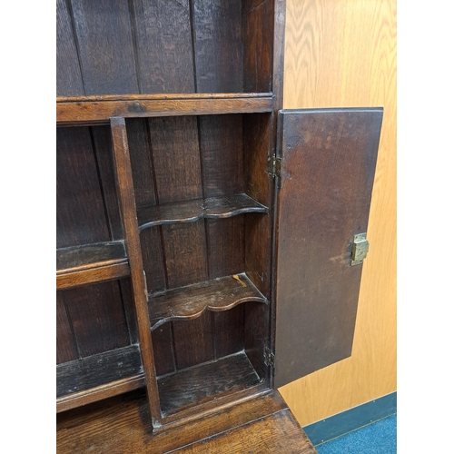 170 - A George III oak cross-banded dresser and rack The ogee cornice above four shelves, the lower flanke... 