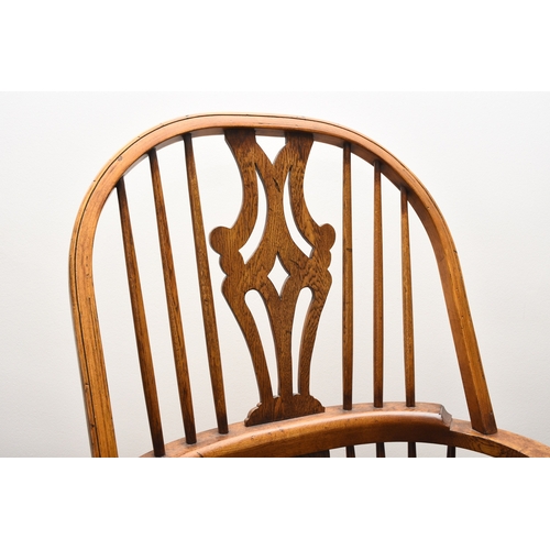 175 - A set of six reproduction ash Windsor armchairs With shaped and pierced splats, the seats raised on ... 