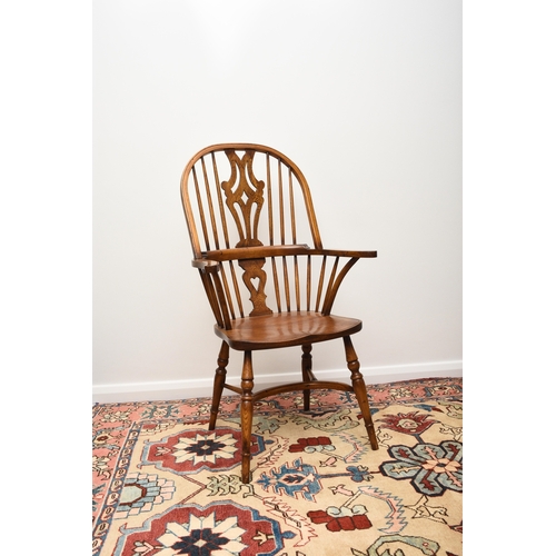 175 - A set of six reproduction ash Windsor armchairs With shaped and pierced splats, the seats raised on ... 