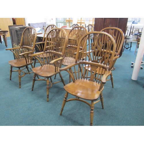 175 - A set of six reproduction ash Windsor armchairs With shaped and pierced splats, the seats raised on ... 