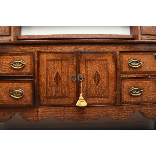 177 - A George III cross-banded oak dresser and rack, Shropshire The open rack with dentil cornice and scr... 