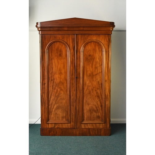 196 - A Victorian mahogany armoire The pedimented ogee cornice above twin arch-panelled doors, the interio... 