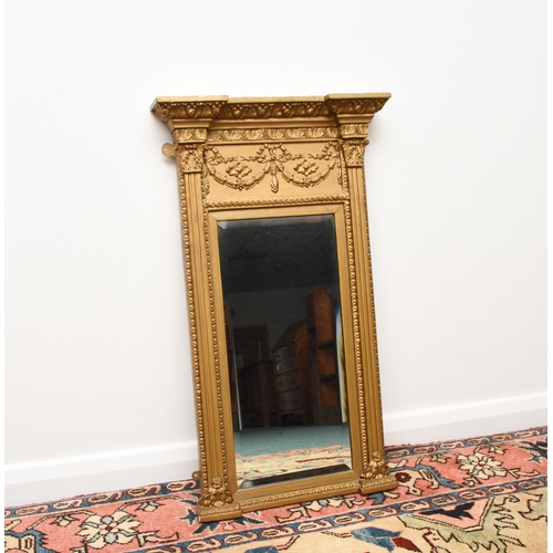 214 - A Regency Revival giltwood pier type wall mirror The bevelled rectangular plate within a frame with ... 