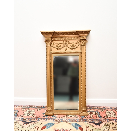 214 - A Regency Revival giltwood pier type wall mirror The bevelled rectangular plate within a frame with ... 