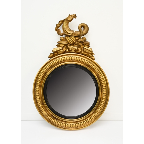 212 - A Regency giltwood and parcel ebonised convex mirror Circa 1820, the circular frame surmounted by a ... 