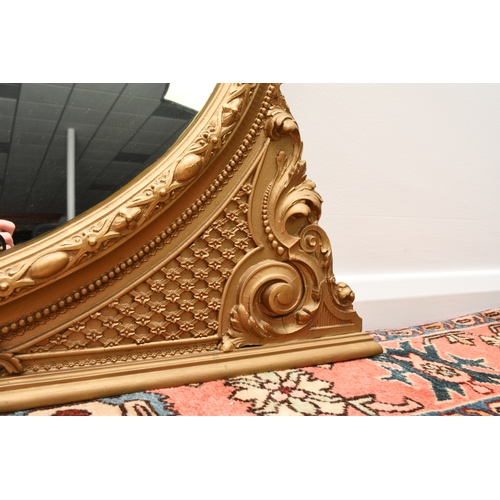 213 - A Victorian giltwood overmantel mirror The oval plate within a moulded frame with shell cresting. 13... 