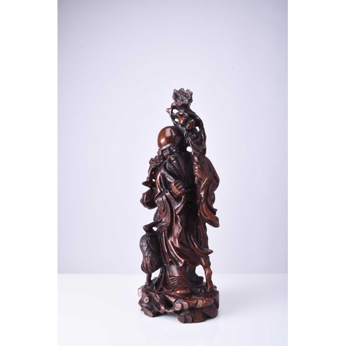 107 - A Chinese carved hardwood figure of Shoulao, late Qing Dynasty Modelled standing and holding a knott... 