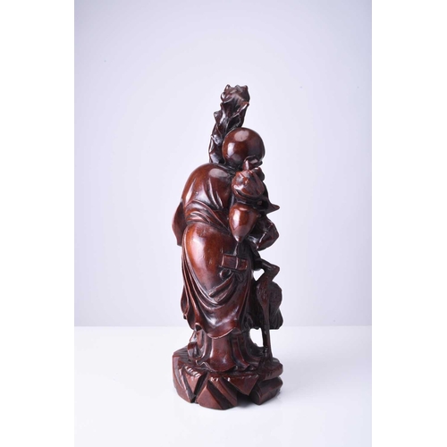 107 - A Chinese carved hardwood figure of Shoulao, late Qing Dynasty Modelled standing and holding a knott... 