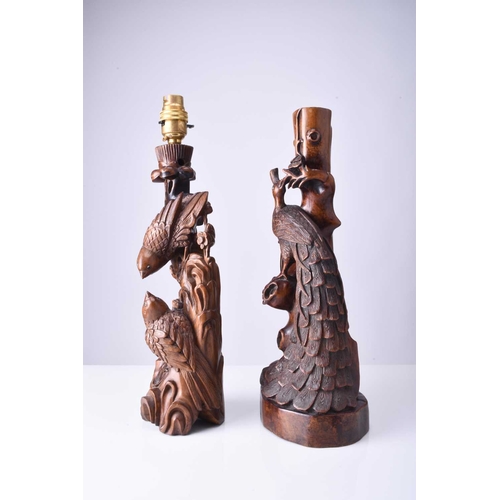 108 - Two Chinese carved hardwood figural lamp bases, Early 20th century The first carved with a peacock p... 