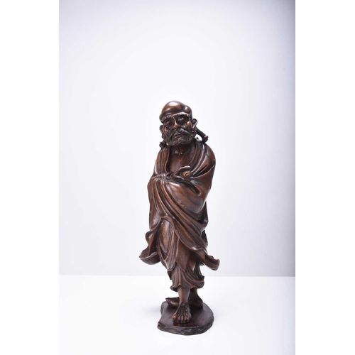 113 - A Chinese carved wood figure of Luohan, Qing Dynasty Modelled standing and holding a scroll. 31cm hi... 