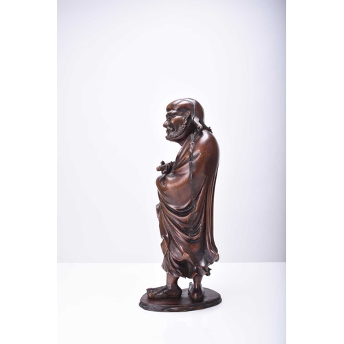 113 - A Chinese carved wood figure of Luohan, Qing Dynasty Modelled standing and holding a scroll. 31cm hi... 