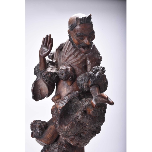 118 - A Chinese carved root wood figure of Luohan, Qing Dynasty Modelled standing on a large knotty root. ... 