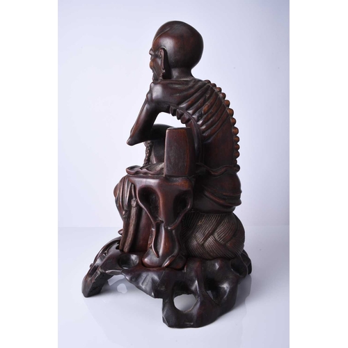 122 - A Chinese carved hardwood figure of a luohan, 19th century The emaciated figure modelled seated and ... 