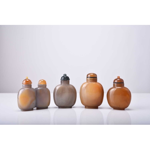 135 - Four Chinese carved agate snuff bottles, 19th century The first of honey colour and carved with a fi... 