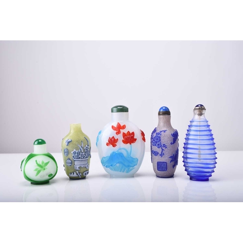 146 - A group of five Chinese overlay glass snuff bottles, 19th/20th century The first mottled green with ... 