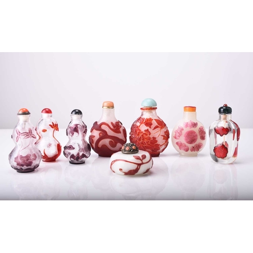 154 - A group of eight Chinese overlay glass snuff bottles, 19th/20th century The first smoky white with p... 