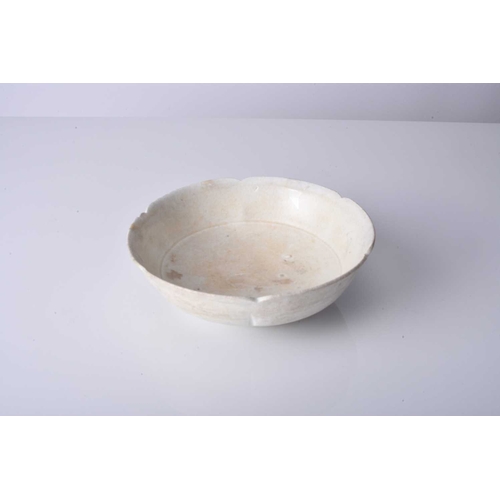 16 - A Chinese ding ware lotus bowl, Song Dynasty Of rounded form with lobed rim, covered in a creamy whi... 