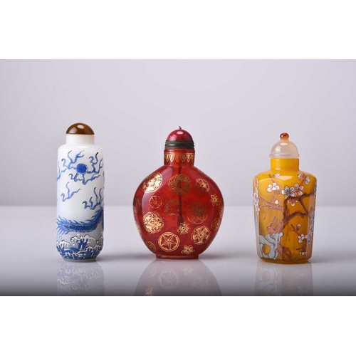 165 - Three Chinese enamelled glass snuff bottles, 19th/20th century The first white of cylindrical form a... 