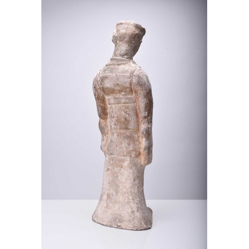 25 - A large Chinese buff pottery figure of a maiden, Sui/Tang Dynasty Modelled standing and wearing long... 