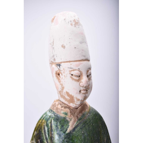 26 - A Chinese Sancai green-glazed standing figure, Tang Dynasty Modelled as an attendant, set on a hexag... 