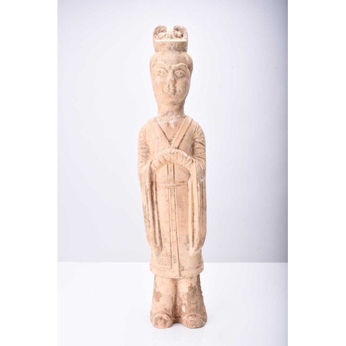 29 - A Chinese buff pottery figure of a maiden, Tang Dynasty Modelled standing and wearing formal robes, ... 