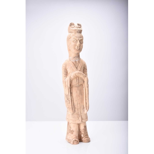 29 - A Chinese buff pottery figure of a maiden, Tang Dynasty Modelled standing and wearing formal robes, ... 