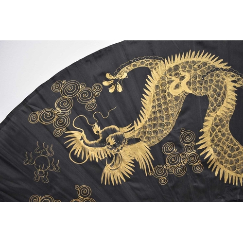 291 - A large decorative painted fan, Thailand, 20th century The black silk painted in gold with a dragon ... 