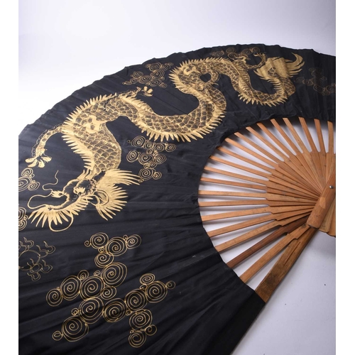 291 - A large decorative painted fan, Thailand, 20th century The black silk painted in gold with a dragon ... 