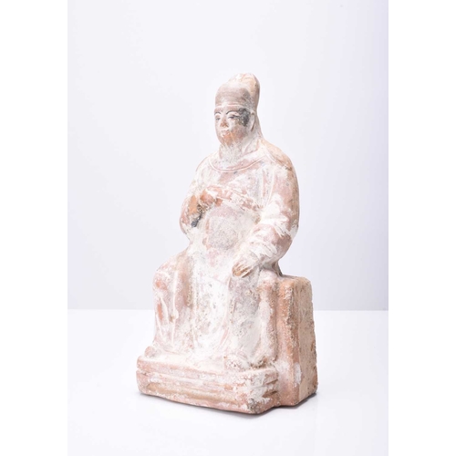 30 - A Chinese buff pottery figure of a seated official, Tang Dynasty 20.5cm high