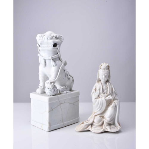 33 - Two Chinese blanc de chine figures, 19th century A seated Guanyin, 18cm high, and a male lion dog on... 