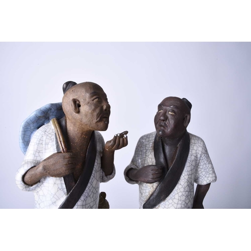 78 - A Chinese pair of Shiwan 'mud' figures, 20th century Modelled as two farmers conversing, applied to ... 