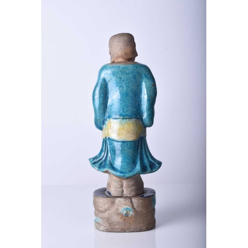 79 - A Chinese sancai glazed figure of an immortal, Ming Dynasty Modelled standing and wearing flowing ro... 