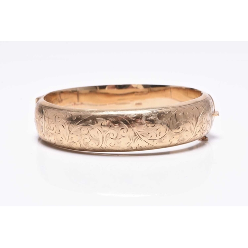 220 - A 9ct gold hinged bangle, with bright cut engraved scroll and foliate decoration, hallmarked Chester... 