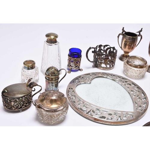 25 - A collection of silverware, comprising; four small silver trophy cups, a pair of silver mounted glas... 