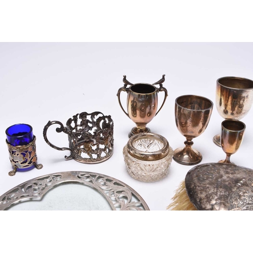 25 - A collection of silverware, comprising; four small silver trophy cups, a pair of silver mounted glas... 